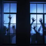 Manos de zombies en un ventanal de oficina, representando los horrores del marketing